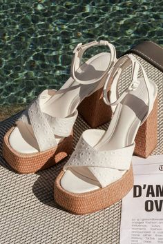 A summer spent with the D'Amelio Footwear Raela White Eyelet Embroidered Platform Ankle Strap Sandals is a summer spent in sensational style! These too-cute sandals start with a raffia-wrapped, 1.5"" toe platform that creates a square footbed, along with floral eyelet embroidered vamp straps that crisscross atop an open-toe upper. A supportive heel strap holds an adjustable ankle strap that secures with a white buckle, all above a matching raffia-wrapped, sky-high block heel. 5" raffia-wrapped h Closed Toe Lace-up Sandals For Beach Vacation, Summer Beach Lace-up Sandals With Ankle Strap, Casual Open Heel Lace-up Sandals For Vacation, White High Heel Wedge Sandals For Summer, Summer Beach Lace-up Wedge Sandals, Spring Platform Open Toe Slingback Sandals, Summer Platform Lace-up Sandals With Block Heel, Chic Open Toe Beach Heels, Beach Chic Open Toe Heels