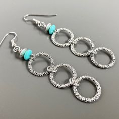 "Silver Hoop Earrings - Small connected Silver Pewter Hoops dangle from Turquoise Czech Glass Beads. The hoops have a pretty texture. Surgical Steel Earwires The hoops are 14mm in diameter (slightly over .5\") Earrings measure just over 2.75\" from top of earwires to bottom of beads." Turquoise Metal Hoop Earrings, Nickel-free Turquoise Circle Jewelry, Turquoise Hoop Metal Jewelry, Turquoise Metal Hoop Jewelry, Nickel-free Turquoise Metal Hoop Earrings, Turquoise Metal Jewelry With Ear Wire, Turquoise Metal Earrings For Pierced Ears, Turquoise Metal Round Hoop Earrings, Turquoise Metal Dangle Earrings