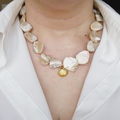 Maui Shelly Necklace has a ivory nacar chain with a shell charm and a toggle clasp. This is a unique and stunning necklace. The details of the pearls will give you a polish look. The baroque Pearls are that classic piece that goes with any trends. Combine Maui Shelly Necklace with Shelly Necklace. Material: Highly polished vacuum 18k Gold Plated & stainless steel for a refined metallic luster, better texture, lasting To Keep Colors! Necklaces come in a Pouch. Necklaces Details: Nacar Chain: 15 inches Stainless Steel & Gold Plated Water Resistance (remember to always clean your jewelry with clear water after you wear them to the pool or to the beach) Does not tarnish and with the right care it can last you for years. Check Our Jewelry Care Instructions. Fashion Tip: Add hops earrings or asy Pearl Drop Shell, Mother Of Pearl Shell With Pearl Drop As Gift, Mother Of Pearl Shell Necklace As Gift, Mother Of Pearl Shell Necklace For Gift, Gift Pearl Drop Shell Made Of Mother Of Pearl, Pearl White Mother Of Pearl Shell Necklace Gift, Pearl White Mother Of Pearl Shell Necklace As Gift, Elegant Mother Of Pearl Shell Pendant Necklace, Elegant Baroque Pearl Shell Necklace As Gift