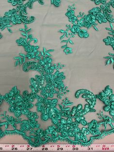 green lace fabric with flowers and leaves on it