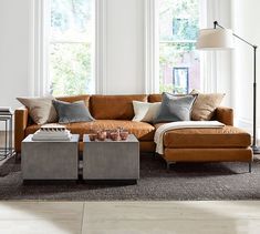 a living room filled with lots of furniture and large windows in the wall behind it