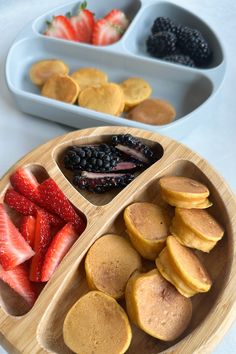 pancakes, strawberries, and berries are arranged in bowls