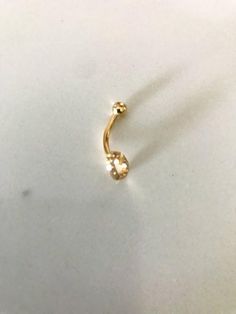 a small gold nose ring on a white surface