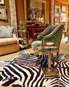 a living room filled with furniture and zebra rugs