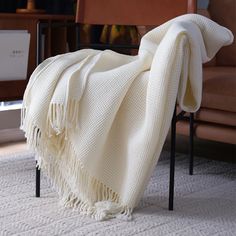 a white blanket sitting on top of a chair