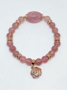 A lovely Rose Quartz barrel and beads are handpicked for this beautifully designed piece of bracelet with high quality rose gold plated spacers with cubic zirconia inserts and a rose charm at the other end of the wrist. This rose quartz is obtained from Madagascar and the energy is of positive vibration for healing and attraction of love. Rose quartz is a stone of universal love. It restores trust and harmony in relationships, encouraging unconditional love. Rose Quartz purifies and opens the he Round Rose Quartz Crystal Bracelet, Spiritual Round Rose Quartz Stretch Bracelet, Pink Rose Quartz Round Beaded Bracelets, Pink Rose Quartz Round Stretch Bracelet, Hand-strung Rose Quartz Bracelets With Round Beads, Red Tourmaline, Shades Of Violet, Pink Rose Quartz, Ancient Coins