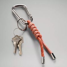 an orange rope wrapped around two keys on a keychain with a metal hook