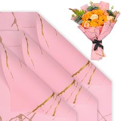 a bouquet of flowers sitting on top of pink wrapping paper