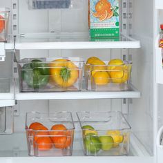 an open refrigerator filled with lots of fruit and veggies in plastic bins