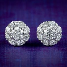 A glamorous pair of Edwardian inspired stud earrings modelled in 18ct white/ yellow gold and adorned with a cluster of sparkling brilliant cut diamonds with superb clarity and colour. The centre stone weighs approx. 0.20ct and is haloed by eight smaller 0.05ct stones, totalling 0.60ct (approx. 1.20ct across both).  They'd be perfect for a wedding or special occasion and glisten beautifully in the light. We recommend you insure for £2,800. We can provide a written Valuation on completion of the s Anniversary Halo Cluster Earrings, Halo Design Cluster Earrings In Cubic Zirconia, Halo Design Cluster Earrings For Anniversary, Dazzling White Diamond Earrings With Pave Setting, Anniversary Cluster Earrings With Halo Setting, Dazzling Cluster Diamond Earrings For Formal Events, Dazzling Cluster Diamond Earrings For Formal Occasions, Anniversary Cluster Diamond Earrings With Accents, Silver Brilliant Cut Cluster Earrings