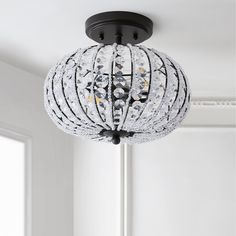 a chandelier hanging from the ceiling in a room with white walls and windows