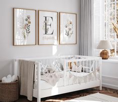 a baby's room with two framed pictures on the wall and a crib