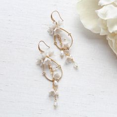 Our Irena teardrop Hoop Floral earrings for Bride are designed to be show stopping dangle hoops that will have everyone asking "where did you get those?!" Crafted with off white flower clusters & dangling freshwater pearls and white opal Austrian crystal beads, these earrings are perfect for casual or formal wear. - Handcrafted with genuine Austrian crystals- Created in my studio in PA- White opal crystals- Freshwater pearls- Polymer clay flowers- Yellow gold finish.- Earrings measure 3.25 inches x 1 inch- Handcrafted in the US.- Nickel free and hypoallergenic- PLEASE ALLOW APPROX 10 BUSINESS DAYS FOR COMPLETION BEFORE SHIPPING.This is an original design by © Treasures by Agnes Bridal Backdrops, Bridal Backdrop Necklace, Earrings For Bride, Gold Bridal Hair Comb, Backdrops Necklace, Crystal Bridal Earrings, Cubic Zirconia Bracelet, Flowers Yellow, Rose Gold Bridal