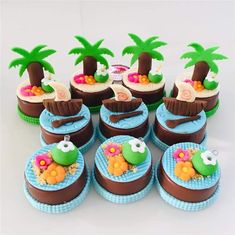 the cupcakes are decorated with fondant palm trees and seashells on them