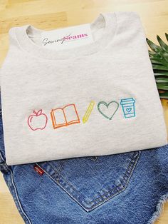 a t - shirt with the word love written on it next to some denim shorts