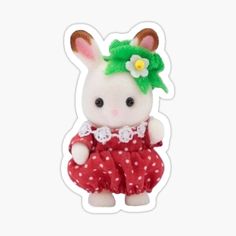 a small stuffed animal wearing a red and white dress with flowers on it's head