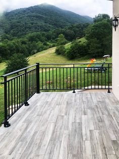 a balcony with black iron railings and wood flooring