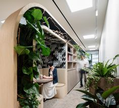 an office filled with plants and people working