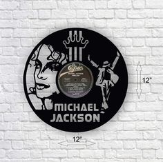 the michael jackson record clock is hanging on a brick wall