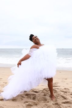 a woman in a white dress on the beach