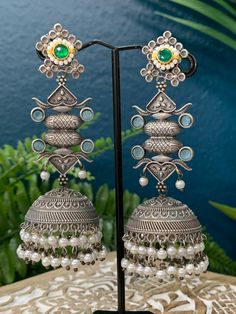 This silver replica statement jhumki earring is crafted with exquisite detail and superior quality. With a combination of kemp stone, kundan work, and pearl drop, these lightweight earrings are sure to be a stylish statement piece. About 4.5inch long and 1.5 inch wide Chandbali Jhumkas For Designer Wear, Chandbali Jhumkas With Cutdana For Designer Wear, Chandbali Cutdana Jhumkas For Designer Wear, Traditional Chandbali Jhumkas For Designer Wear, Bollywood Style Designer Earrings With Cutdana, Festive Designer Jhumkas With Latkans, Bollywood Cutdana Earrings For Designer Wear, Bollywood Designer Cutdana Earrings, Kundan Jhumkas For Festivals