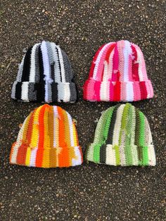 three knitted hats laying on the ground