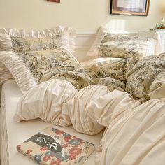 a bed with white sheets and pillows on top of it next to a framed picture