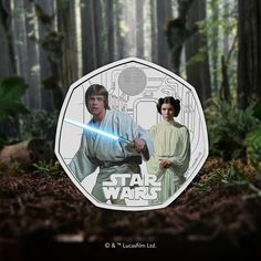 a star wars coin with luke and leion holding lightsabes in the forest