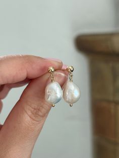 These gorgeous Baroque Pearl Drop Earrings are a timeless addition to your jewelry collection. The bold yet lightweight Pearl makes a statement, yet is simple enough to go with any outfit. Each oval/slighly irregular Pearl set is matched, but no two Pearls are the same making each pair special and unique. These make gorgeous bridal earrings or they're perfect for any special event! * 14K Gold Filled or 925 Sterling Silver 4mm ball stud and accents * 1 inch length * 9x13mm organic shape Baroque P Classic Single Pearl White Earring, White 14k Gold Filled Bridal Earrings As Gift, 14k Gold Filled White Bridal Earrings As Gift, Classic White 14k Gold Filled Jewelry, 14k Gold Dangle Bridal Earrings As Gift, Anniversary Bridal Earrings With Pearl Drop In Yellow Gold, Anniversary Bridal Earrings In Yellow Gold With Pearl Drop, Anniversary Yellow Gold Bridal Earrings With Pearl Drop, Timeless 14k Gold Filled Wedding Jewelry