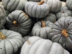 many white pumpkins are stacked on top of each other