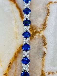 This 18K white gold bracelet features individual links set with round Blue Sapphires and White Diamonds. Sapphires total 5.58ctw in carat weight Diamonds total 1.71ctw in carat weight Luxury Blue Sapphire Bracelets, Blue Hand Set Diamond Bracelet As Gift, Blue Hand Set Fine Jewelry Bracelet, Luxury Blue Bracelets With Hand Set Details, Hand Set Blue Diamond Bracelet As Gift, Blue Fine Jewelry Bracelet Hand Set, Luxury Blue Tennis Bracelet, Luxury Blue Diamond Bracelet With Brilliant Cut, Blue Diamond Bracelet With Brilliant Cut Luxury Style