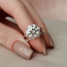 a woman's hand with a ring on her finger and a diamond in the middle