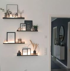 some shelves with pictures and candles on them in a room that is decorated with black and white decor