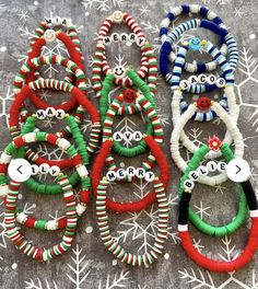 several bracelets with words on them sitting next to snowflakes and christmas decorations