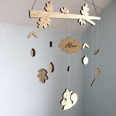 a crib mobile with leaves and acorns hanging from it