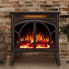 a fireplace with a fire burning in it next to a chair and brick wall behind it