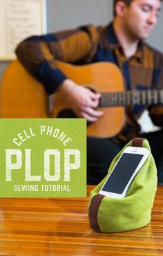 a cell phone sitting on top of a green bag next to a sign that says cell phone plop