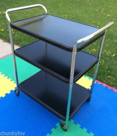 a three tiered cart sitting on top of a blue mat