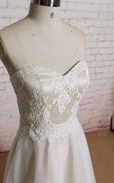 a white dress on a mannequin in front of a brick wall and floor