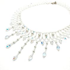 This Beaded Swarovski Crystal and Pearl Bridal Statement Necklace is a collar style with gorgeous teardrop pendants. It is and one of a kind.  All My pieces are made with the finest materials available. I only use genuine Swarovski Crystals and Pearls. They are strung on Fireline which is knotted throughout the piece. Sterling silver or gold filled clasps are standard making my pieces heirloom quality to be handed down to future brides. I used 6 and 4 mm white Swarovski Pearls, 6 and 4 mm Clear AB Swarovski bicones, 9 mm teardrop crystals, white pearl finish seed beads and a sterling clasp. This took 10 hours to make but the finished product is sooo worth it! If you want to make a statement, this is your piece. This is the one and only piece exactly like this and is ready to ship now. I wi Wedding Necklace With Dangling Beads, Handmade Teardrop Necklaces For Wedding, Handmade Teardrop Necklace For Wedding, Handmade Elegant Drop Beaded Necklaces, Elegant Beaded Teardrop Crystal Necklaces, White Faceted Beads Necklace For Wedding, White Faceted Bead Wedding Necklace, White Crystal Dangle Necklaces, White Beaded Drop Jewelry