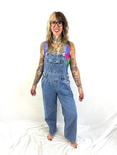 Nice overalls Size medium. Great vintage shape 100% cotton Made in Bangladesh Lying flat: 18" across waist 21" across hips 50" top to bottom front center 28" inseam Retro Dark Wash Cotton Denim Jumpsuit, High Rise Medium Wash Relaxed Fit Overalls, High Rise Relaxed Fit Overalls In Medium Wash, Vintage Light Wash Denim Overalls, 90s Style Blue Denim Overalls, 90s Blue Cotton Denim Jumpsuit, 90s Style Blue Cotton Denim Jumpsuit, Retro Dark Wash Denim Jumpsuit, Retro Cotton Overalls With Relaxed Fit