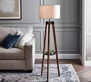 a living room scene with focus on the floor lamp and sofa in the foreground