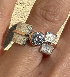 a woman's hand with two different rings on it and one has a diamond in the middle