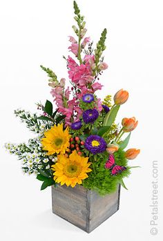 a vase filled with lots of different colored flowers