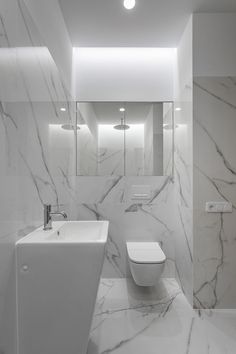 a bathroom with white marble walls and floor