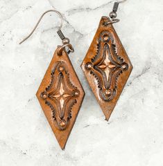 "Made using premium veg tan leather, these earrings are hand stamped and dyed.  A bit of copper colored paint adds a bit of sparkle to the design.  2\" long (including ear wire) and 3/4\" wide." Rustic Hand Tooled Leather Jewelry, Brown Southwestern Jewelry With Patina, Southwestern Brown Jewelry With Patina, Rustic Hand Tooled Leather Earrings, Brown Southwestern Teardrop Jewelry, Southwestern Style Brown Teardrop Jewelry, Southwestern Style Teardrop Brown Jewelry, Southwestern Brown Teardrop Jewelry, Brown Stamped Copper Jewelry