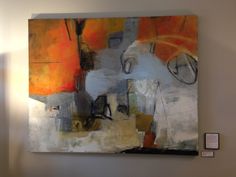 an abstract painting hangs on the wall