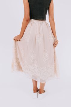 The Everglow Skirt combines feminine elegance with comfort, featuring an embroidered floral overlay and elastic waistband. Perfect for any occasion, this skirt will have you feeling stylish and carefree. (Floral and functional? This skirt's got you covered!) Details Embroidered floral overlay Elastic waistband Sizing Approximate measurements: SIZE LENGTH WAIST Small 35" 28" Medium 36" 30" Large 37" 32" XLarge 37" 34" Fabric has stretch in the waistbandModel is 5’10 wearing small Material 100% Po Beige Flowy Skirt For Spring, Spring Beige Skirt With Elastic Waistband, Beige Skirt With Elastic Waistband For Spring, Spring Garden Party Long Skirt, Feminine Beige Skirt For Spring, Feminine Beige Midi Bottoms, Spring Full Maxi Skirt With Elastic Waistband, Spring Flowy Skirt With Elastic Waistband, Spring Flared Dress With Floral Embroidery