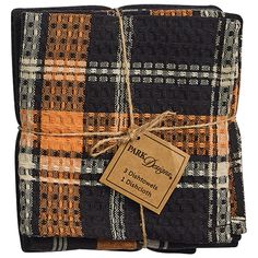 two pieces of black and orange plaid fabric with a brown tag on the end of each piece