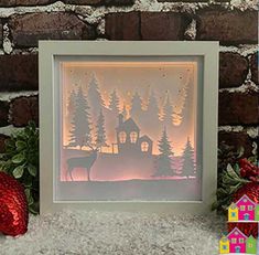 a paper cut out of a house with trees and a deer in the foreground